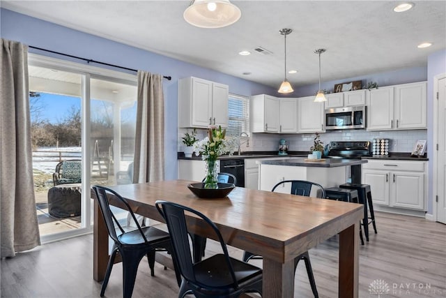 dining room with sink and light hardwood / wood-style flooring