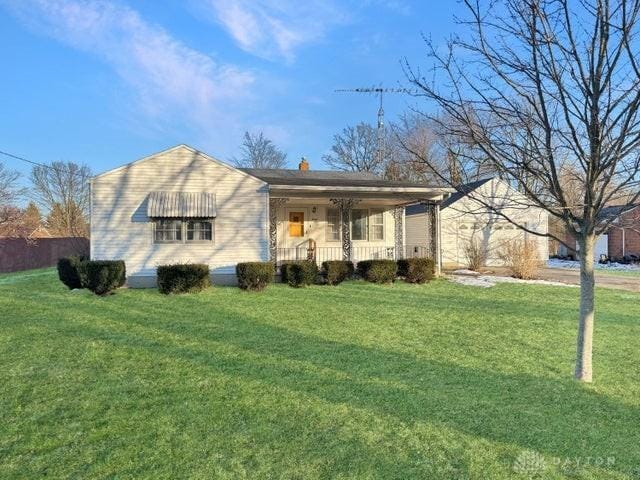 ranch-style home featuring a front lawn and covered porch