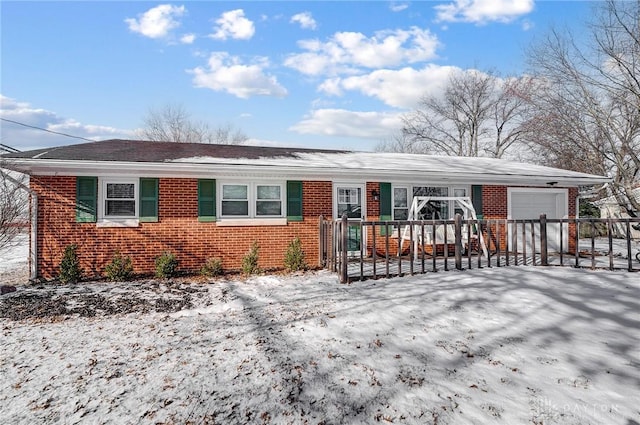 ranch-style home with brick siding, an attached garage, and fence