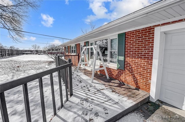 snow covered deck with a garage