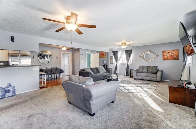 carpeted living room with ceiling fan and a textured ceiling