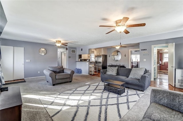 carpeted living room featuring ceiling fan