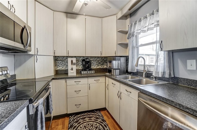 kitchen with appliances with stainless steel finishes, dark hardwood / wood-style floors, tasteful backsplash, sink, and ceiling fan