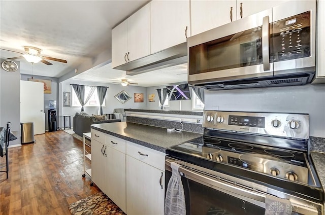 kitchen featuring dark wood-type flooring, ceiling fan, stainless steel appliances, and white cabinets