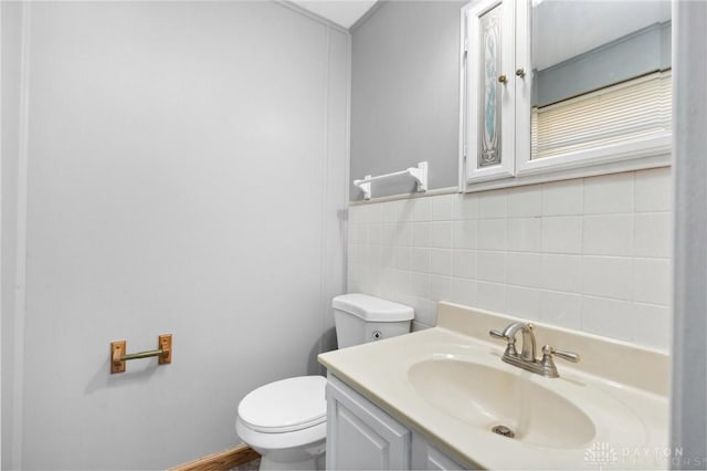 bathroom featuring vanity, toilet, and tile walls