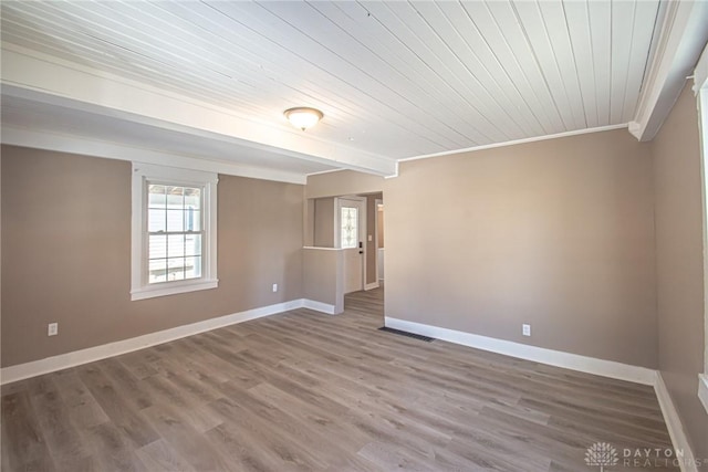 spare room featuring beamed ceiling, ornamental molding, hardwood / wood-style floors, and wood ceiling