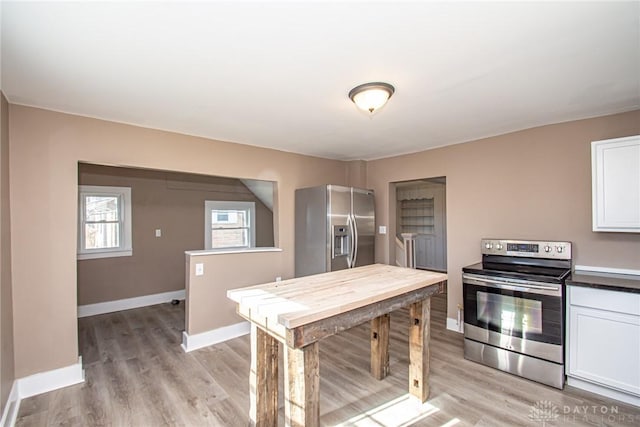 kitchen featuring stainless steel appliances, light hardwood / wood-style floors, and white cabinets