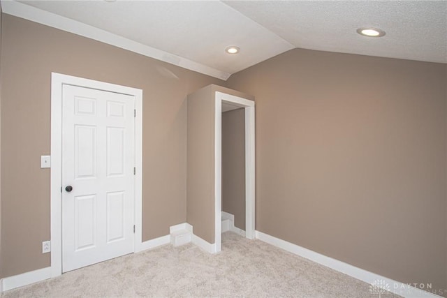 interior space with vaulted ceiling and a textured ceiling