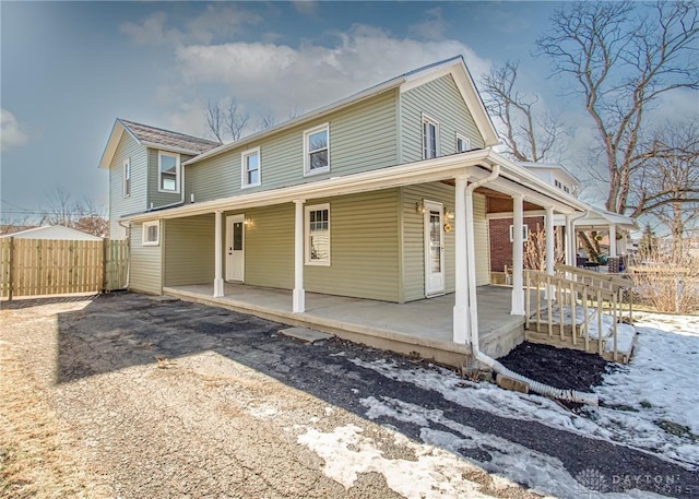 snow covered property featuring covered porch