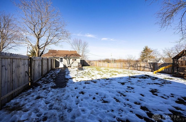 yard covered in snow featuring an outbuilding and a playground