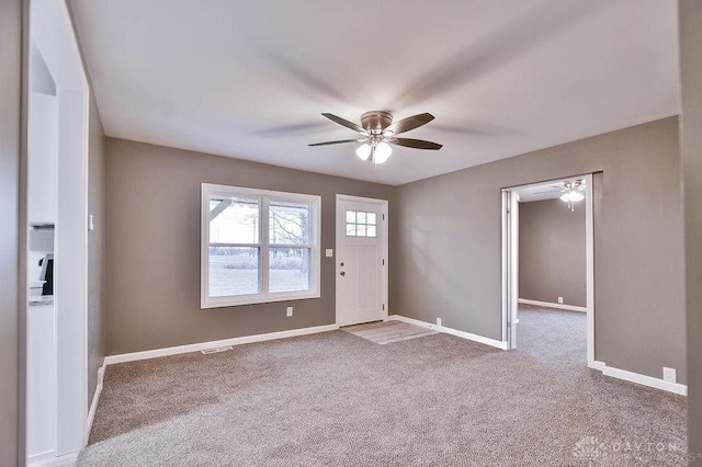 foyer featuring ceiling fan and carpet flooring