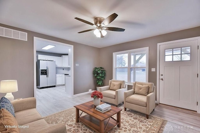 living room featuring light hardwood / wood-style floors and ceiling fan