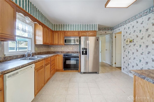 kitchen with appliances with stainless steel finishes, sink, and light tile patterned floors