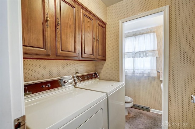 clothes washing area with cabinets and washing machine and dryer