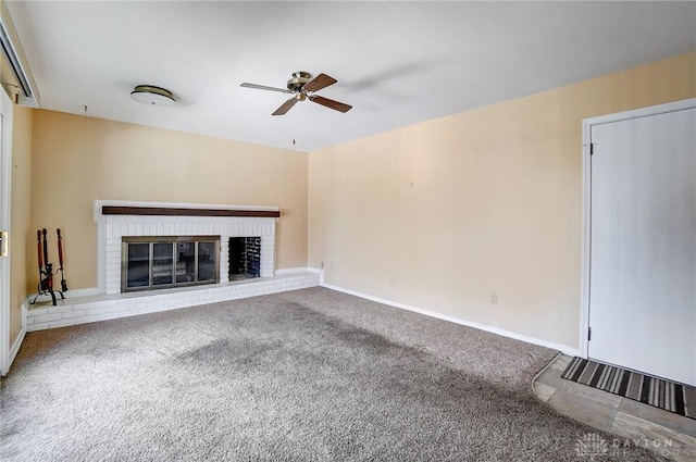 unfurnished living room with ceiling fan, carpet flooring, and a brick fireplace