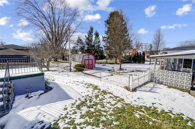 yard covered in snow featuring a storage shed