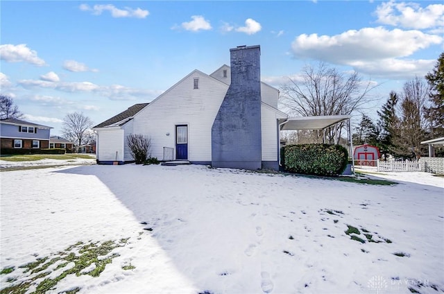 view of snowy exterior with a storage unit