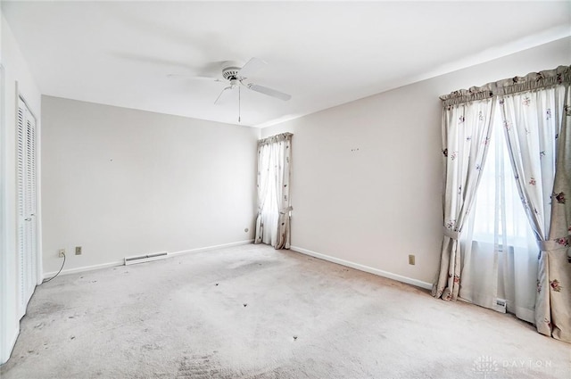 empty room with ceiling fan and light carpet