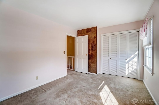 unfurnished bedroom featuring a closet and light carpet