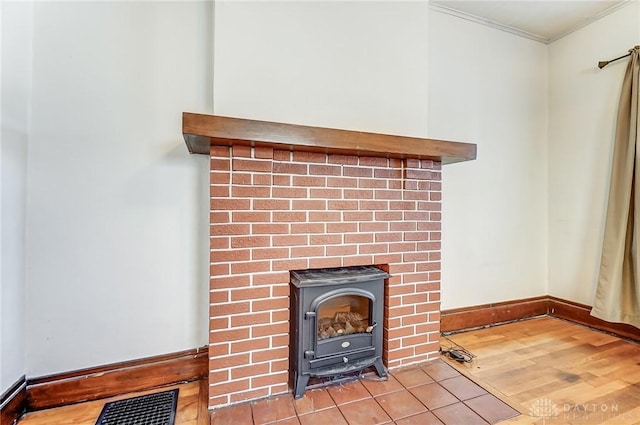 room details featuring hardwood / wood-style flooring, ornamental molding, and a wood stove