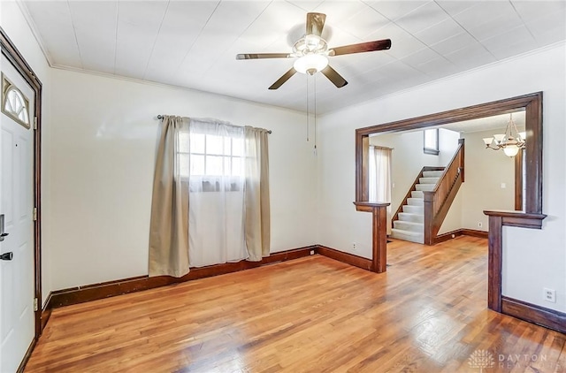 foyer entrance with hardwood / wood-style flooring, ornamental molding, and ceiling fan