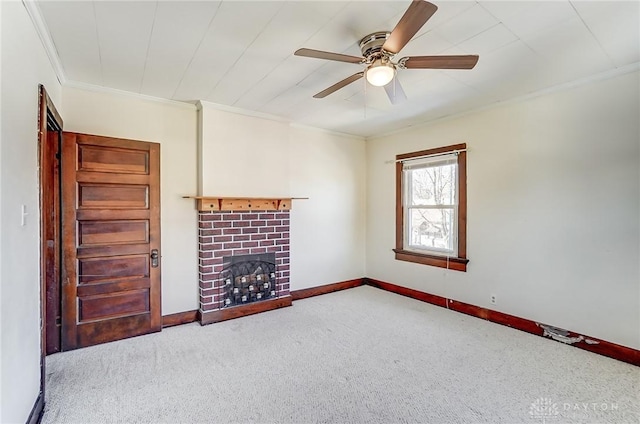 unfurnished living room featuring crown molding, ceiling fan, a fireplace, and light carpet