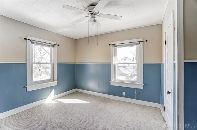 carpeted spare room featuring ceiling fan