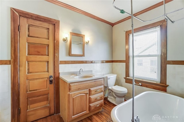 bathroom with ornamental molding, wood-type flooring, tile walls, and a tub