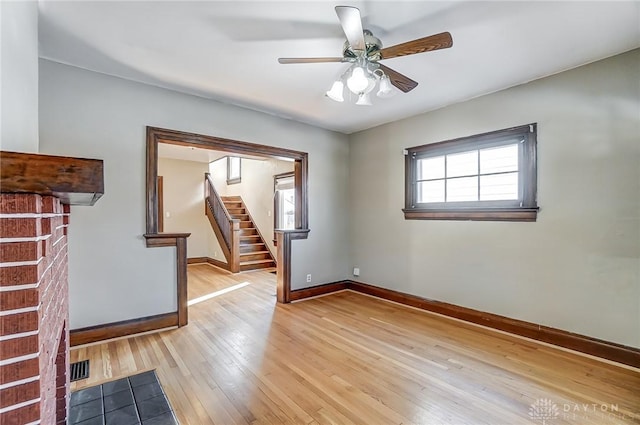 unfurnished living room featuring ceiling fan and light hardwood / wood-style floors