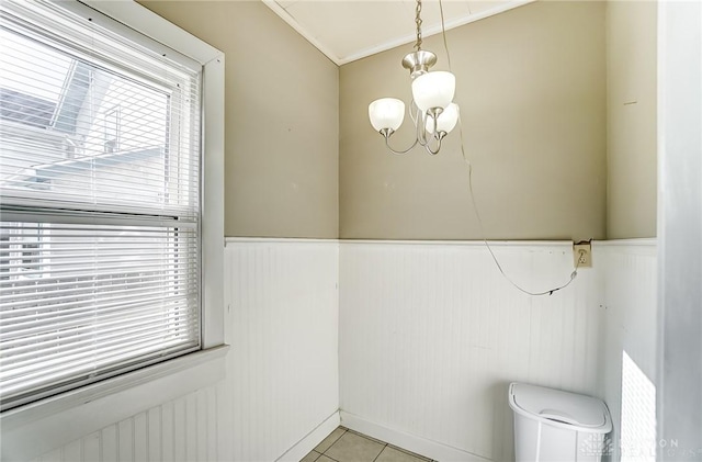 bathroom featuring tile patterned flooring, ornamental molding, and a notable chandelier