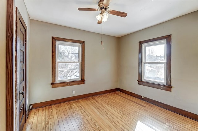 spare room with light hardwood / wood-style flooring, a wealth of natural light, and ceiling fan