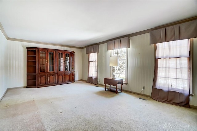 unfurnished room featuring ornamental molding and light colored carpet