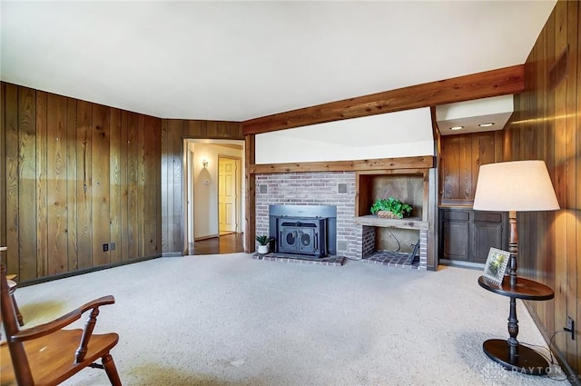 carpeted living room featuring beamed ceiling and wood walls