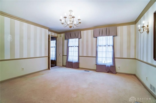 unfurnished room featuring crown molding, carpet flooring, and an inviting chandelier