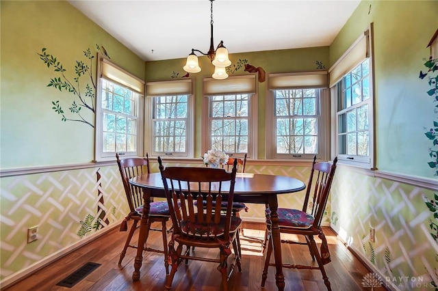 dining area with an inviting chandelier and dark wood-type flooring