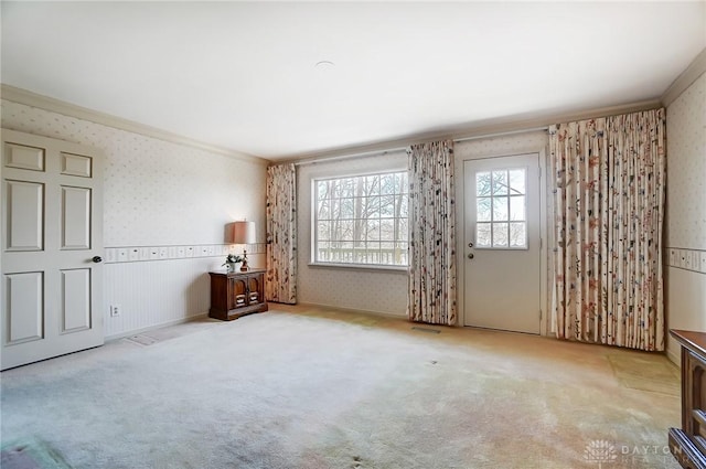 unfurnished room featuring crown molding and light carpet