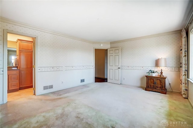 unfurnished bedroom with crown molding and light carpet