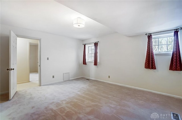 unfurnished room with light colored carpet and a healthy amount of sunlight