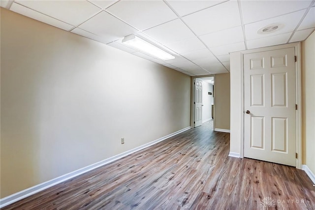 unfurnished room with a drop ceiling and light wood-type flooring