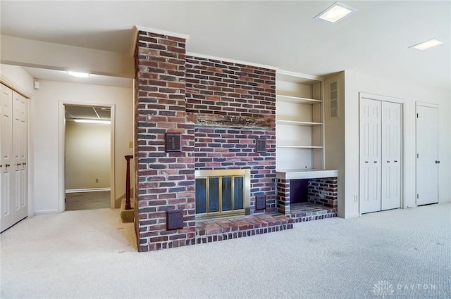 unfurnished living room with built in shelves, light colored carpet, and a fireplace