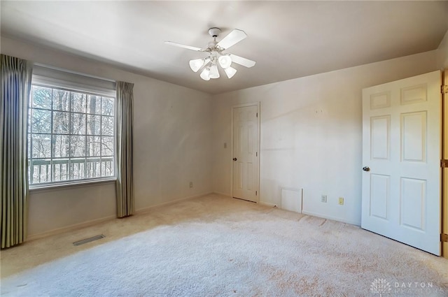 spare room featuring light carpet and ceiling fan