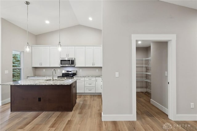 kitchen with sink, appliances with stainless steel finishes, white cabinetry, a center island with sink, and decorative light fixtures