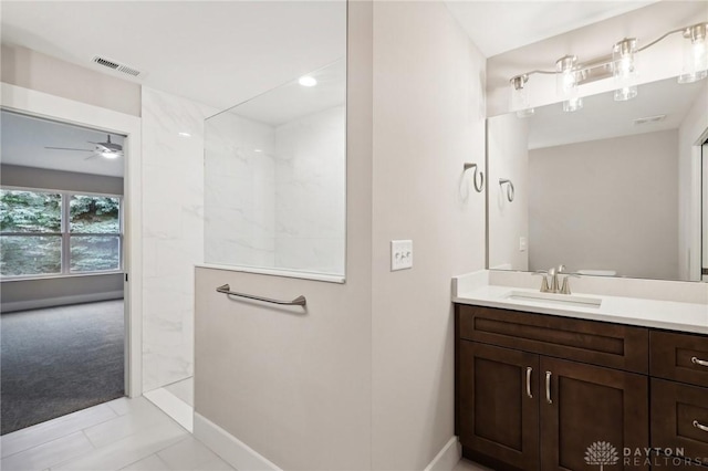 bathroom with vanity, ceiling fan, and a tile shower