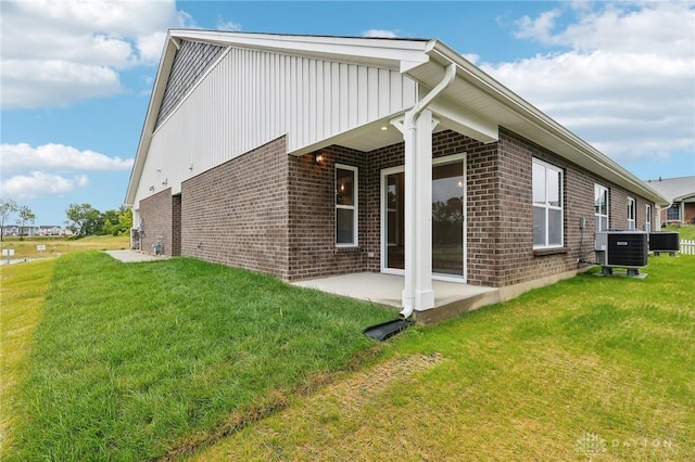 back of house with a yard, a patio, and central air condition unit