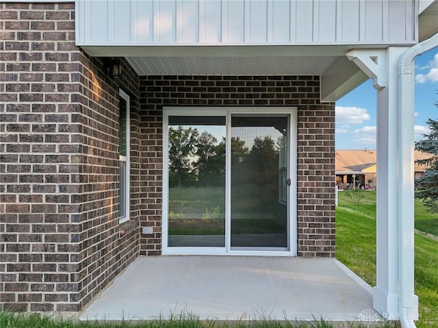 view of exterior entry with a patio area