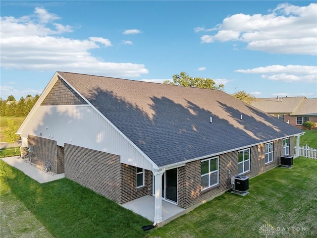 rear view of house with a lawn, a patio, and central air condition unit