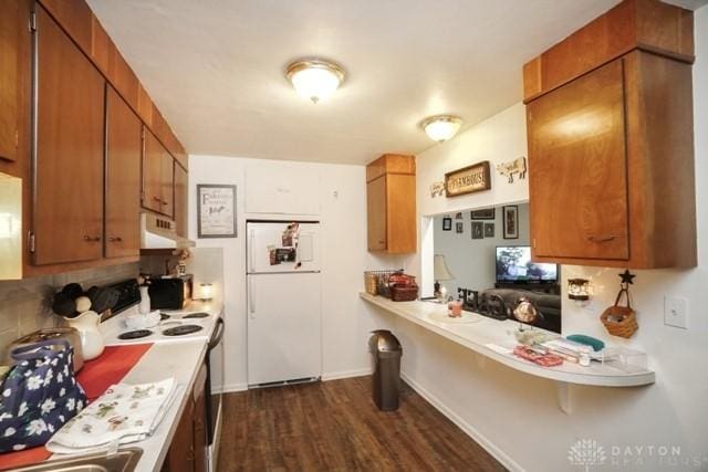 kitchen featuring white appliances and dark hardwood / wood-style flooring