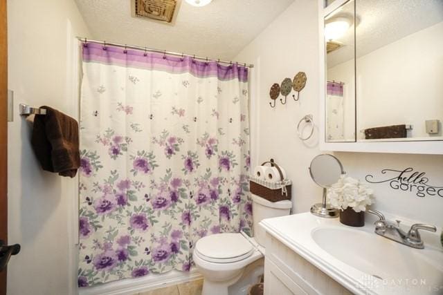 bathroom with vanity, a textured ceiling, and toilet