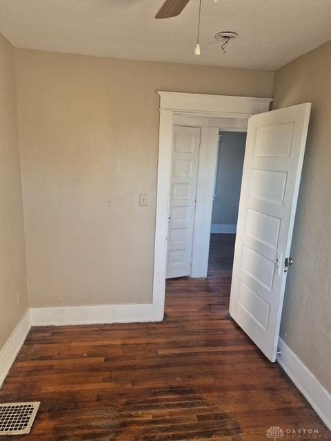 empty room featuring ceiling fan and dark hardwood / wood-style flooring