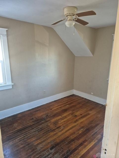 additional living space with dark hardwood / wood-style flooring, vaulted ceiling, and ceiling fan